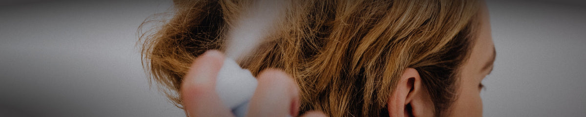 Hairspray being misted over wavy golden styled hair