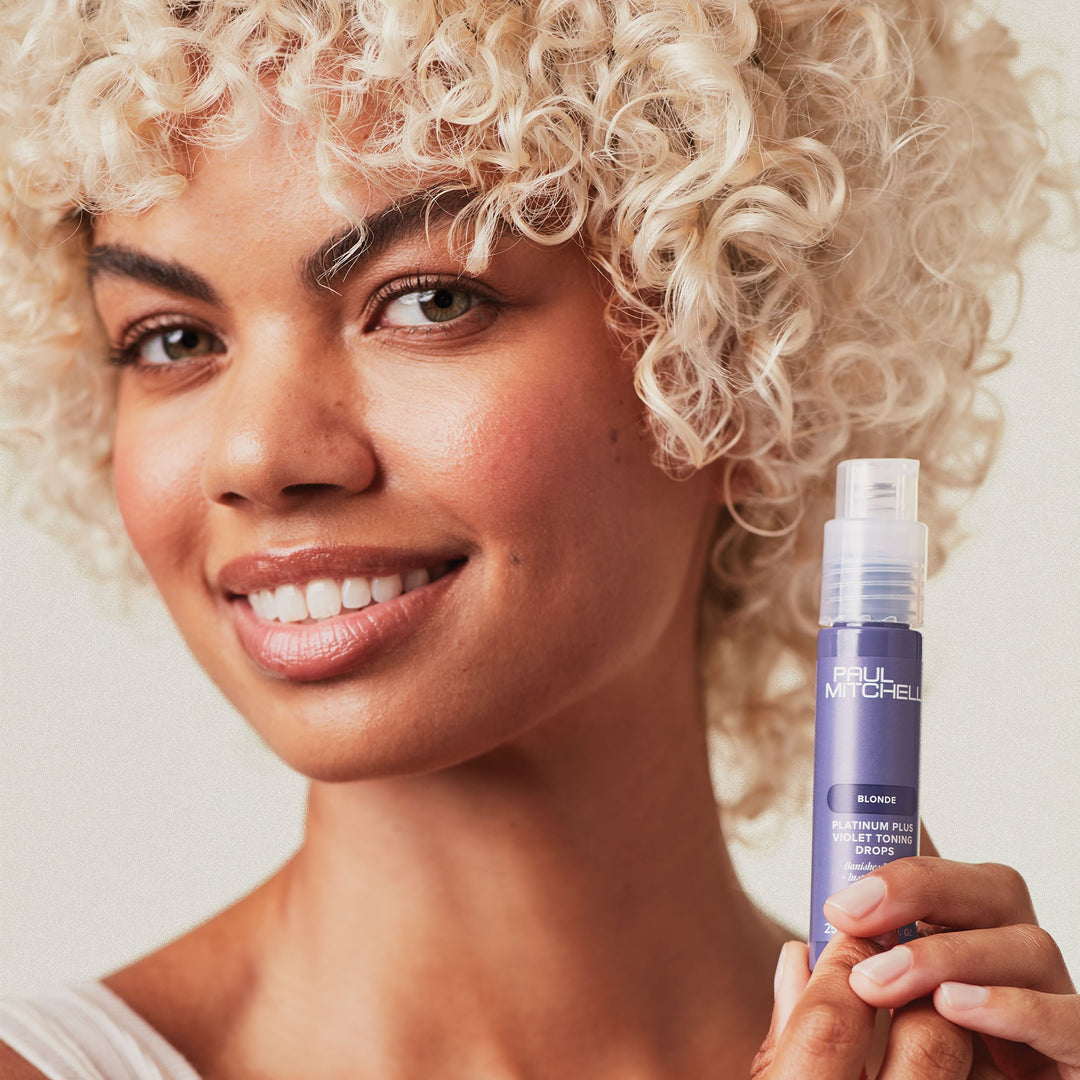 Paul Mitchell Platinum Plus Violet Toning Drops - model holding the bottle