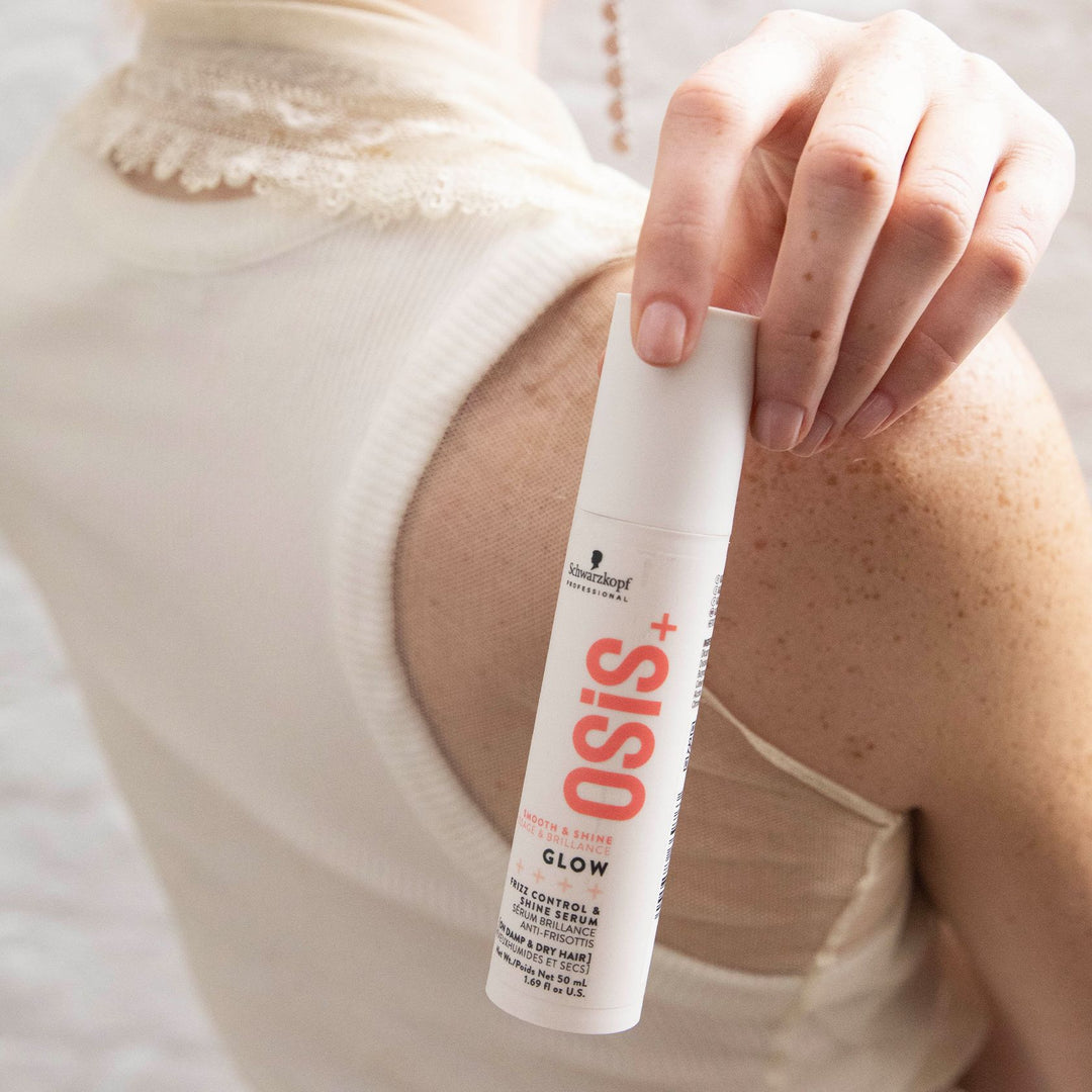 OSiS+ Glow shine serum bottle held against a model