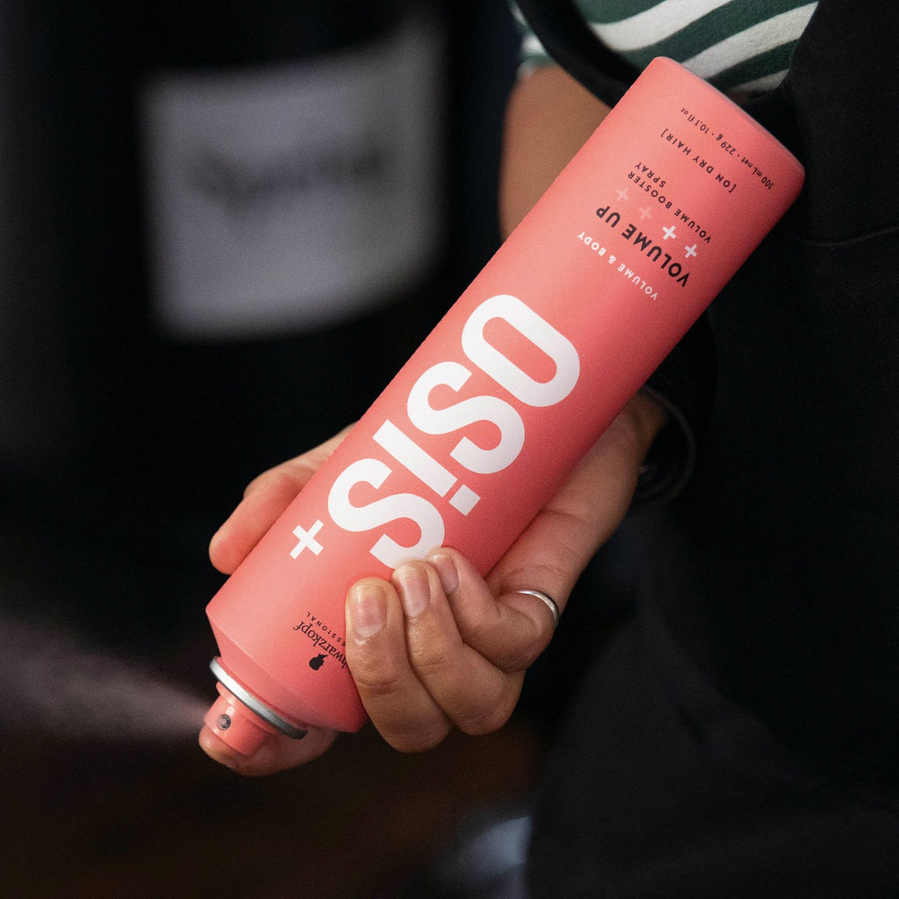 OSiS+ Volume Up Volume Booster Spray held by a stylist